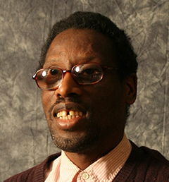 Headshot of Chester Finn. Chester wears glasses and a brown suit.