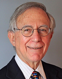 Headshot of James Perrin. James wears a suit and tie.