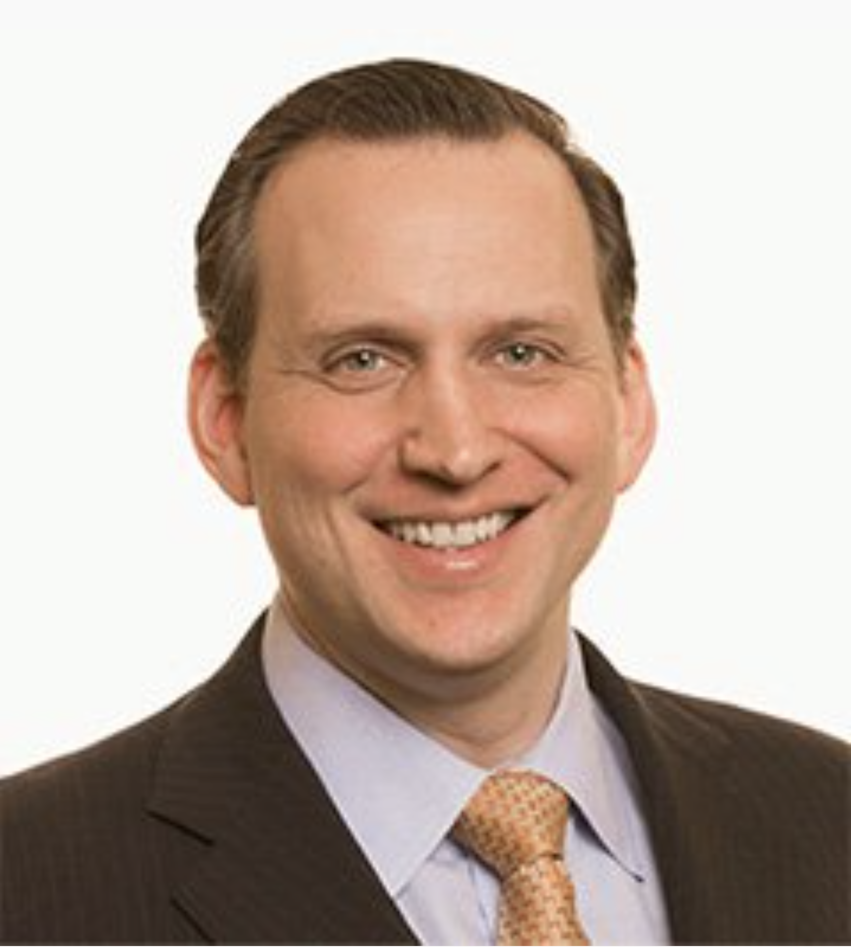 Headshot of Matthew Holder. Matthew wears a brown suit and yellow tie.