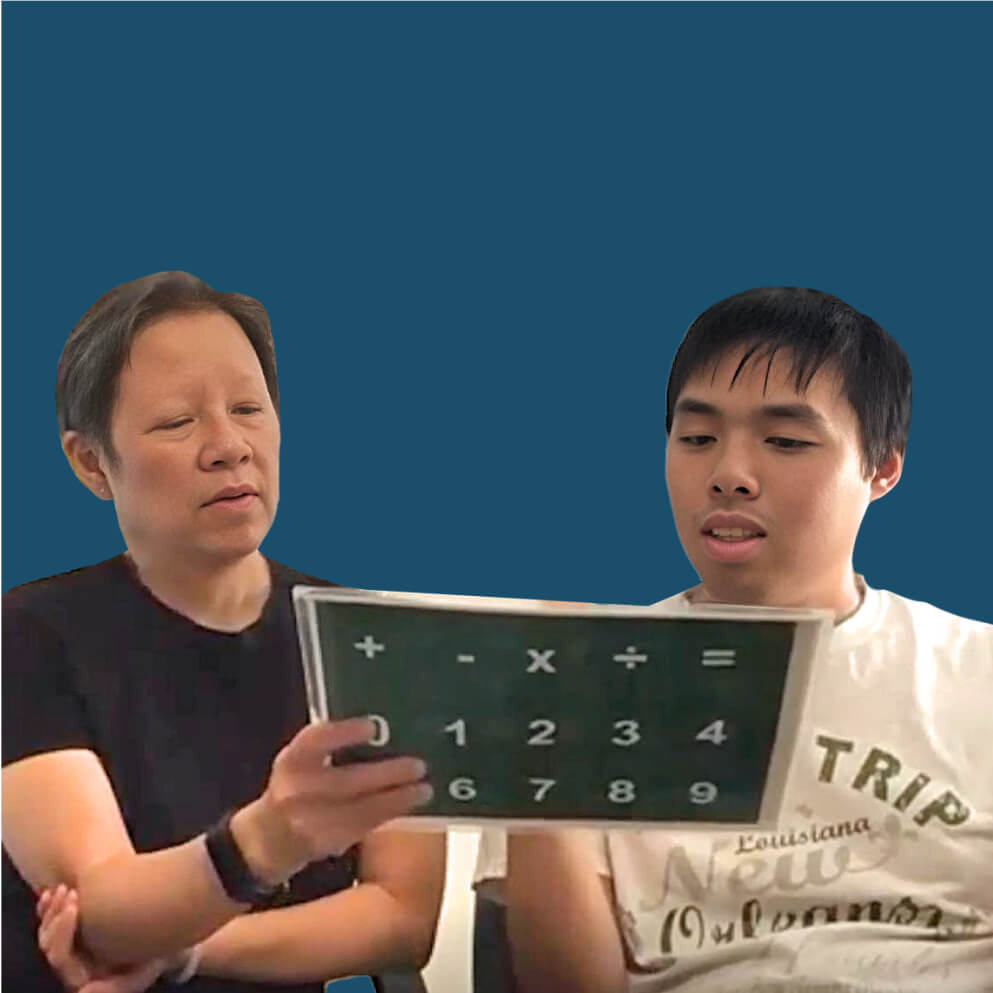 A photo of an instructor and student practicing math on a letterboard. The instructor wears a black shirt, and the student wears a white shirt.